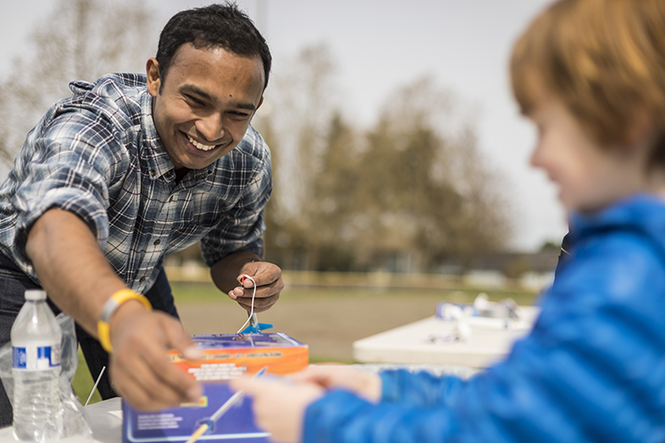 Gaurav Mukherjee helps an elementary school student learn how to launch rockets at a Northwest Earth and Space Sciences event